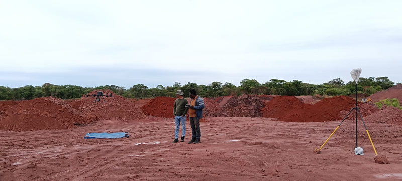 Surveyors planning a mission beside laterite spoil heaps