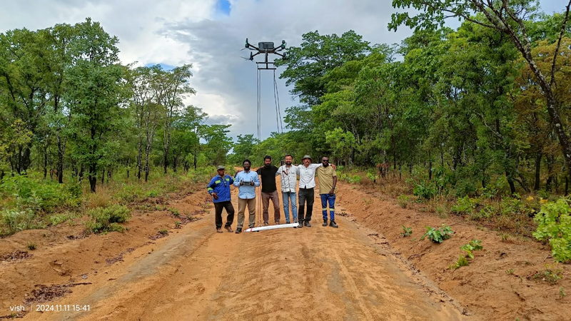 Field team with an airborne magnetometer system on a forest survey track